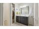Bathroom showcasing double sinks, a large mirror, and a walk-in closet at 36033 W Catalonia Dr, Maricopa, AZ 85138