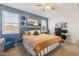Bedroom featuring an accent wall, two windows, and a dedicated workstation at 36033 W Catalonia Dr, Maricopa, AZ 85138