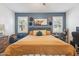 Spacious primary bedroom featuring a king bed, two windows, and an accent wall at 36033 W Catalonia Dr, Maricopa, AZ 85138