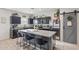 Modern kitchen featuring a large island, stainless steel appliances, granite countertops, and dark wood cabinets at 36033 W Catalonia Dr, Maricopa, AZ 85138