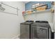 Convenient laundry room with front load washer and dryer and blue painted accent wall at 36033 W Catalonia Dr, Maricopa, AZ 85138