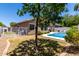 A backyard featuring a swimming pool, a grassy area, and a house with a covered patio at 3719 E Sandy Way, Gilbert, AZ 85297
