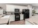Functional kitchen with white cabinetry, black appliances, and neutral countertops at 3719 E Sandy Way, Gilbert, AZ 85297
