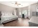 Light-filled main bedroom with a ceiling fan, a work station, and large windows at 3719 E Sandy Way, Gilbert, AZ 85297