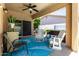 Cozy covered patio area features a ceiling fan and a variety of comfortable seating options at 3719 E Sandy Way, Gilbert, AZ 85297
