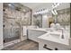 Luxurious bathroom with marble shower, dual sinks, and elegant lighting creating a relaxing and sophisticated space at 3800 E Lincoln Dr # 31, Phoenix, AZ 85018