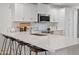 Bright kitchen with stainless steel appliances, island sink, countertop seating and white cabinetry at 3800 E Lincoln Dr # 31, Phoenix, AZ 85018