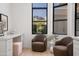 A light-filled sitting room featuring modern decor, comfortable seating, and a view of the manicured backyard at 3800 E Lincoln Dr # 31, Phoenix, AZ 85018