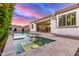 Inviting backyard pool and spa with travertine tile, surrounded by lush greenery and a covered patio at 3884 S Wilson Dr, Chandler, AZ 85286