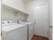Functional laundry room with white appliances, shelving, and convenient access at 4212 E Jasper Dr, Gilbert, AZ 85296