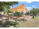 Community playground with a large canopy, play structure, and green surroundings at 4212 E Jasper Dr, Gilbert, AZ 85296