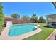 Sparkling pool in a landscaped backyard with lush greenery and privacy fencing at 45138 W Norris Rd, Maricopa, AZ 85139