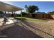 Backyard featuring a covered patio, mature trees, grass, gravel ground cover, and wood fence at 4608 W Gail Dr, Chandler, AZ 85226
