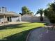 Large backyard featuring lush green grass, mature trees, and a concrete block wall surrounding the property at 4608 W Gail Dr, Chandler, AZ 85226