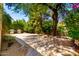 Relaxing outdoor area featuring pavers, a built-in fire pit and lush trees for shade at 5234 E Carol Ave, Mesa, AZ 85206