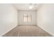This carpeted bedroom offers a clean design, ceiling fan, and ample natural light at 5234 E Carol Ave, Mesa, AZ 85206