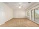 The bedroom has plush carpet, a ceiling fan, and shuttered windows offering ample light at 5234 E Carol Ave, Mesa, AZ 85206