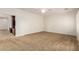 A spacious bedroom features neutral carpet, a ceiling fan, and a built-in entertainment center at 5234 E Carol Ave, Mesa, AZ 85206