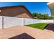 Spacious backyard with desert landscaping, privacy wall, and small turf area under a blue sky at 715 S Saranac Ave, Mesa, AZ 85208