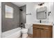 Modern bathroom featuring gray tiled shower, new fixtures, stylish vanity, and new flooring at 715 S Saranac Ave, Mesa, AZ 85208