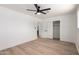 Bright bedroom featuring wood floors, a ceiling fan, and white walls with closet for storage at 715 S Saranac Ave, Mesa, AZ 85208