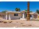 Single-Gathering home showcasing a neutral stucco exterior, arched entry, rock landscaping, and a two-car garage at 715 S Saranac Ave, Mesa, AZ 85208