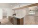 Kitchen area featuring an island with stainless steel appliances and open sightlines into the living area at 715 S Saranac Ave, Mesa, AZ 85208