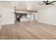 Spacious living area featuring light hardwood floors, a ceiling fan, and a modern chandelier at 715 S Saranac Ave, Mesa, AZ 85208