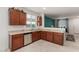Galley-style kitchen with wood cabinets, a stainless steel dishwasher, and a window view of the backyard at 7224 W Puget Ave, Peoria, AZ 85345