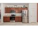 Efficient kitchen with stainless steel appliances, wood cabinetry, tile floors, and a convenient pantry at 7224 W Puget Ave, Peoria, AZ 85345