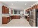 Spacious kitchen featuring stainless steel appliances, tile floors, wood cabinets, and open layout into living area at 7224 W Puget Ave, Peoria, AZ 85345