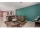 Comfortable living room featuring a teal accent wall, plush sectional, and a cozy fireplace, perfect for relaxation at 7224 W Puget Ave, Peoria, AZ 85345