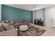 Comfortable living room featuring a teal accent wall, plush sectional, and a cozy fireplace, perfect for relaxation at 7224 W Puget Ave, Peoria, AZ 85345