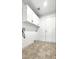 Functional laundry room with tile floor, storage cabinets, and a utility sink at 7243 W Sandra Ter, Peoria, AZ 85382
