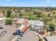 An aerial view of the golf course and clubhouse with lush green fairways, palm trees, and ample parking space at 7430 E Ed Rice Ave, Mesa, AZ 85208