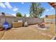 Backyard area with a brick fire pit, seating, and a view of the block wall and neighboring trees at 7431 W Mclellan Rd, Glendale, AZ 85303