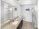 Bright bathroom with double sink vanity, granite countertop, and glass enclosed shower at 8218 W Illini St, Phoenix, AZ 85043
