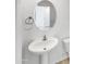 Bright bathroom features a pedestal sink, round mirror, and modern fixtures at 8218 W Illini St, Phoenix, AZ 85043