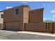 Side view of the tan home showing the two-car garage and fenced yard at 8218 W Illini St, Phoenix, AZ 85043