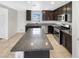 Modern kitchen with dark cabinets, granite countertops, stainless steel appliances, and large island at 8218 W Illini St, Phoenix, AZ 85043