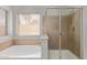 Bathroom featuring a soaking tub with tile surround and glass enclosed shower at 871 W Mesquite St, Gilbert, AZ 85233
