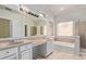 Bright bathroom with double sinks, soaking tub, walk-in shower, and tiled flooring at 871 W Mesquite St, Gilbert, AZ 85233