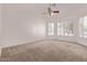 Bright, carpeted bedroom with large windows and a ceiling fan at 871 W Mesquite St, Gilbert, AZ 85233