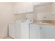 Bright laundry room with washer, dryer, sink and overhead cabinets for storage at 871 W Mesquite St, Gilbert, AZ 85233