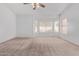 Spacious living room features a large window and ceiling fan with neutral colored walls and carpet at 871 W Mesquite St, Gilbert, AZ 85233
