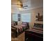 Comfortable bedroom with two twin beds, ceiling fan, closet with mirrored doors, and bright natural light at 9205 W Williams St, Tolleson, AZ 85353