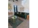 Stylish living room featuring a green velvet sofa, modern decor, and ample natural light at 9205 W Williams St, Tolleson, AZ 85353