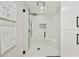 Modern walk-in shower with a glass enclosure, tiled walls, black hardware, and a built-in shower seat at 10538 E Gold Dust Cir, Scottsdale, AZ 85258