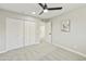 A bright bedroom with a neutral color scheme, ceiling fan, and large closet doors at 10538 E Gold Dust Cir, Scottsdale, AZ 85258