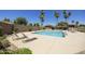 Relaxing community pool with lounge chairs and lush landscaping in the background at 10538 E Gold Dust Cir, Scottsdale, AZ 85258